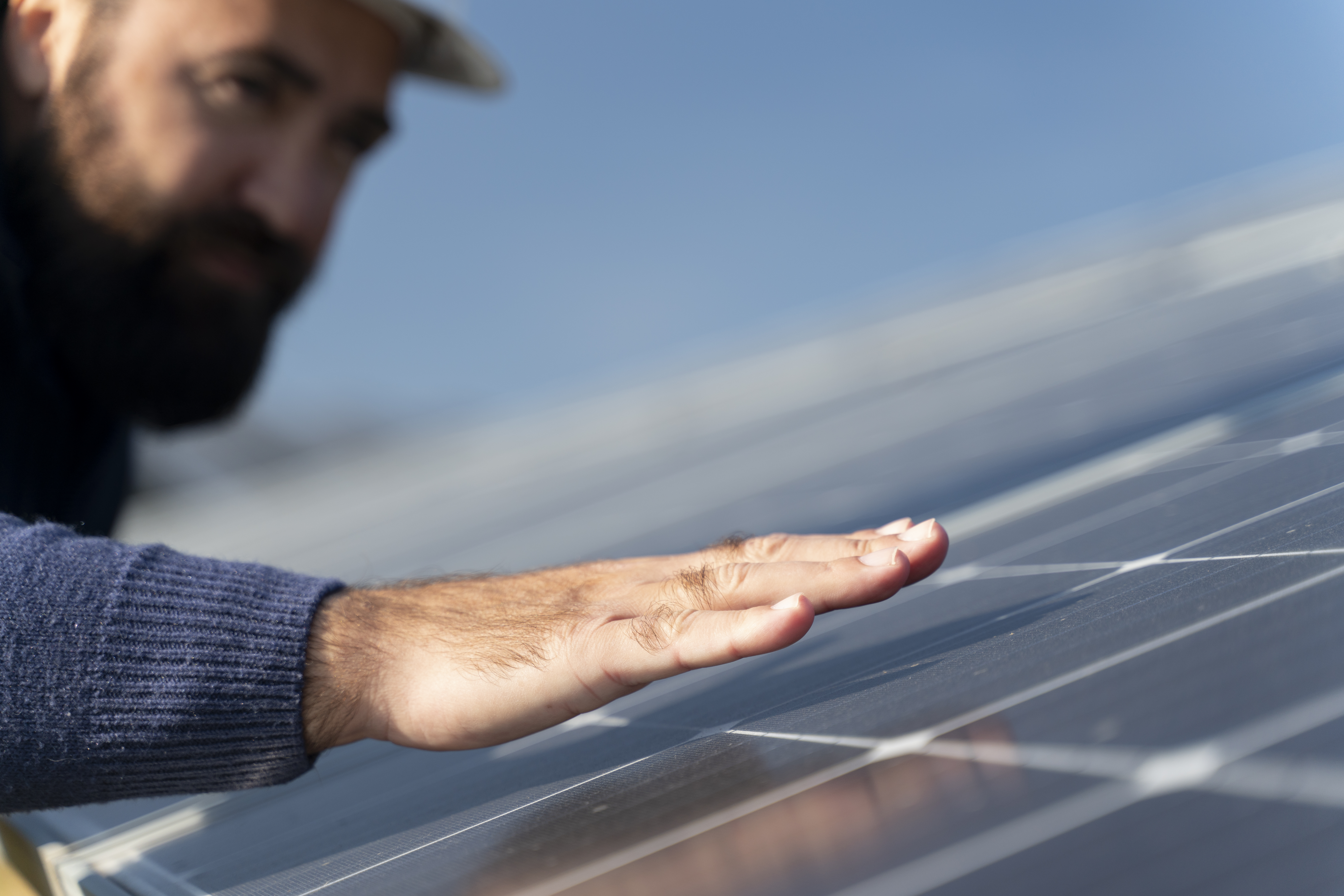 Técnico comprobando el rendimiento de paneles solares, símbolo de resiliencia e independencia energética.